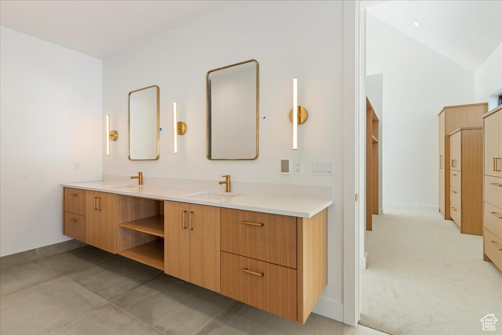 Bathroom featuring vanity, lofted ceiling, and tile floors