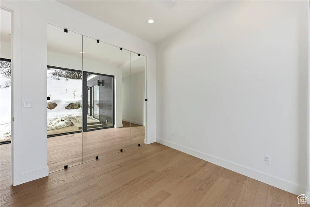 Empty room with light hardwood / wood-style floors and a wealth of natural light