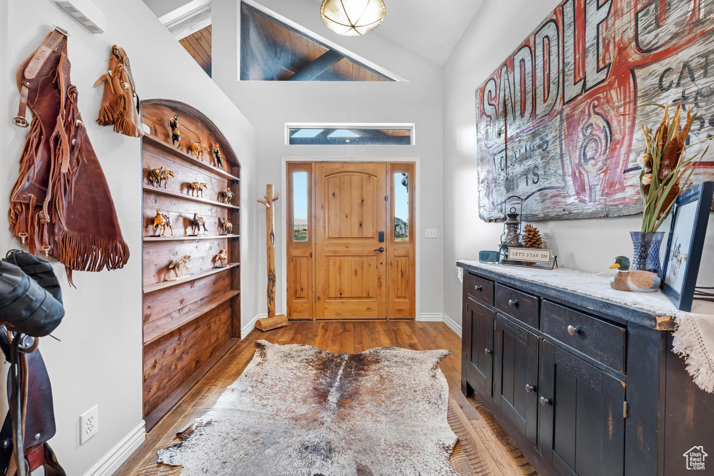 Entryway with light wood-type flooring and vaulted ceiling