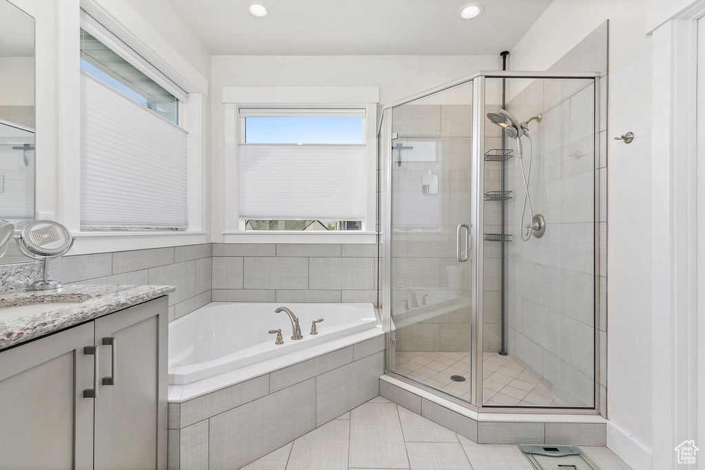 Bathroom featuring oversized vanity, tile floors, and independent shower and bath