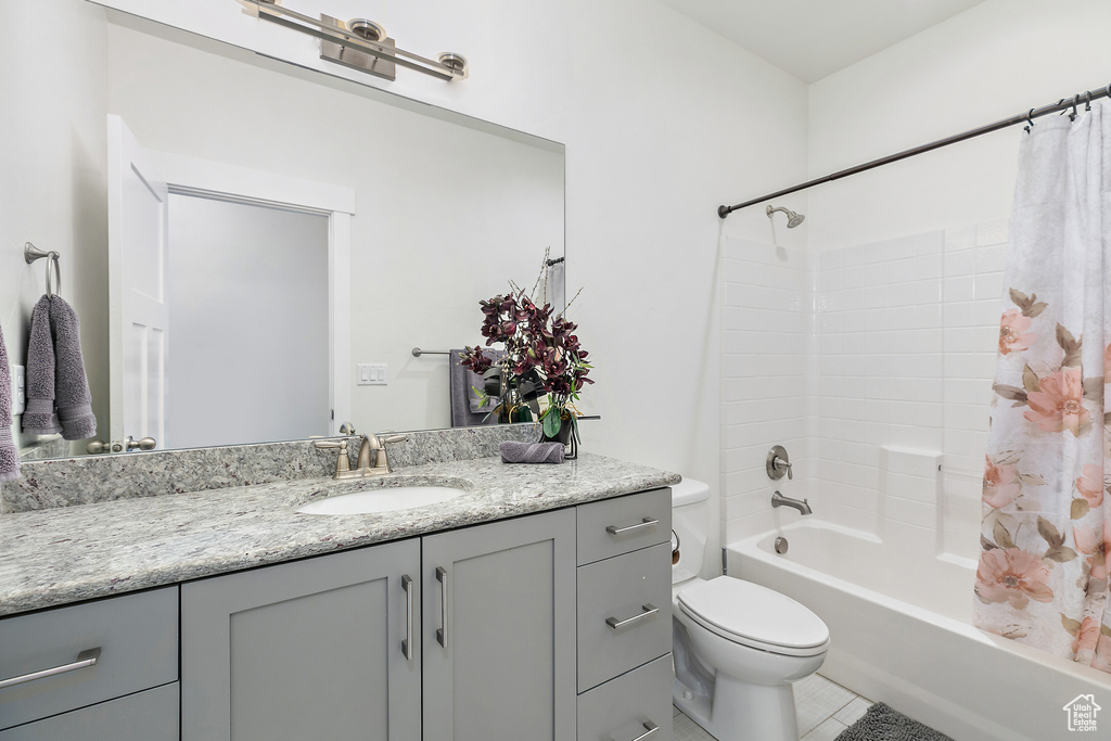 Full bathroom with shower / bath combo, large vanity, tile floors, and toilet