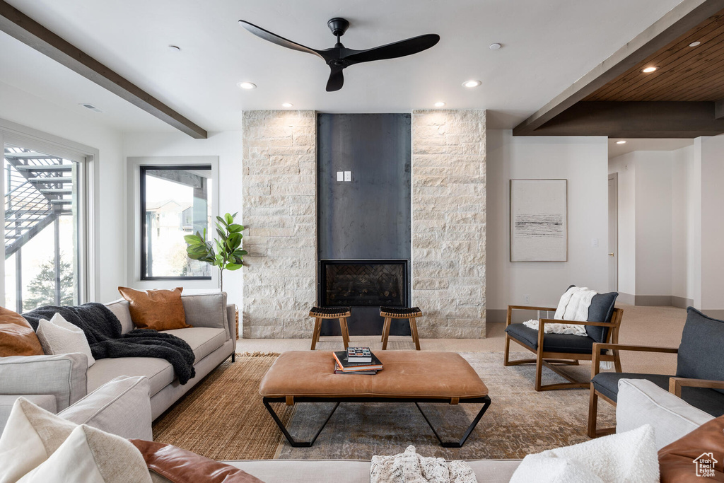 Living room featuring ceiling fan and a stone fireplace
