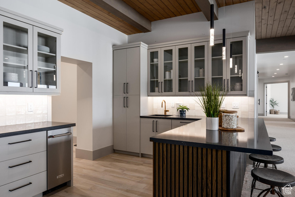 Kitchen featuring wood ceiling, light hardwood / wood-style floors, backsplash, white cabinets, and sink
