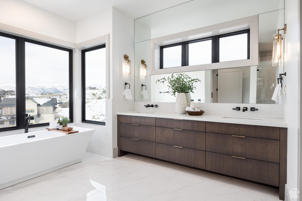 Bathroom with a wealth of natural light, tile floors, and vanity