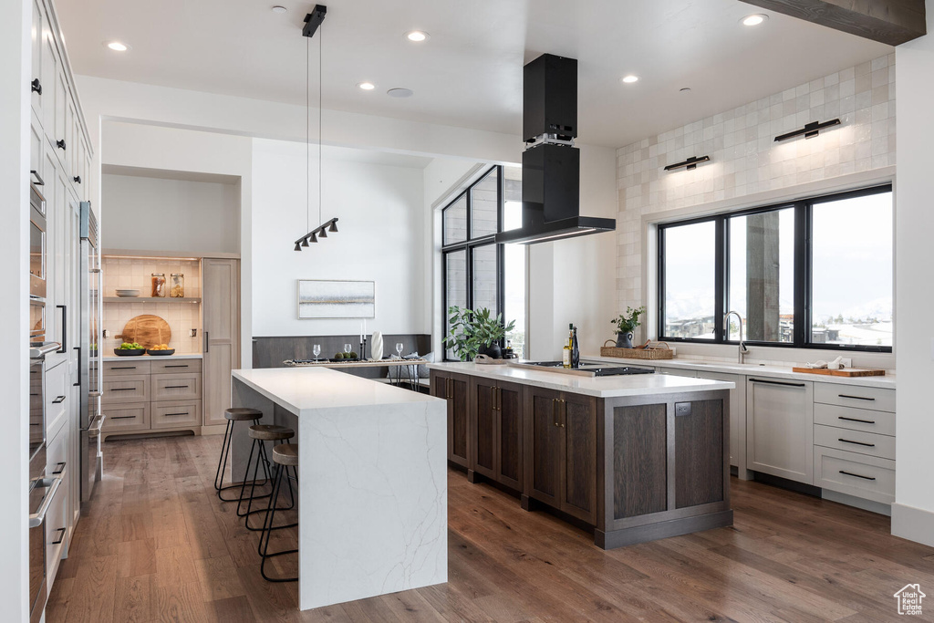 Kitchen featuring pendant lighting, island range hood, and dark hardwood / wood-style floors