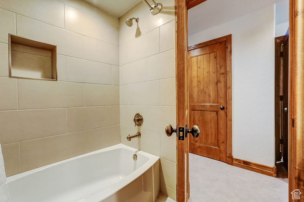 Bathroom with tile walls and tiled shower / bath combo
