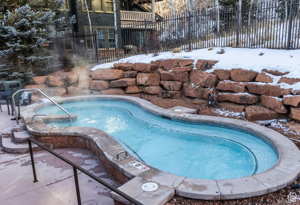 View of swimming pool featuring a patio and an in ground hot tub
