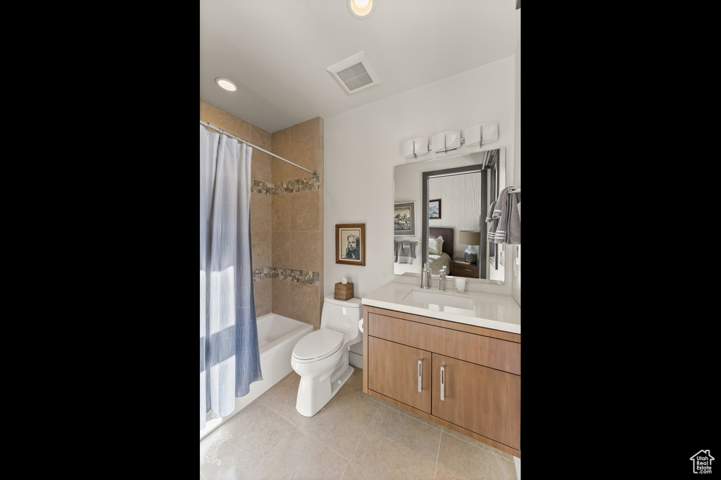 Full bathroom featuring toilet, shower / bath combo with shower curtain, large vanity, and tile flooring