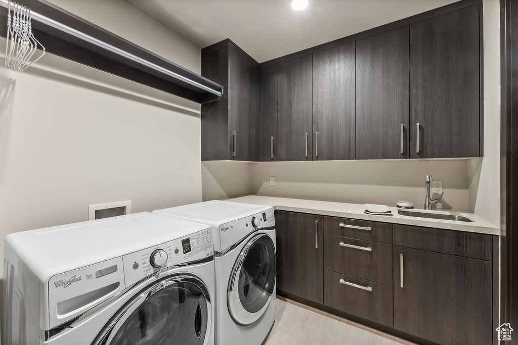 Laundry area featuring washer and clothes dryer, hookup for a washing machine, and cabinets