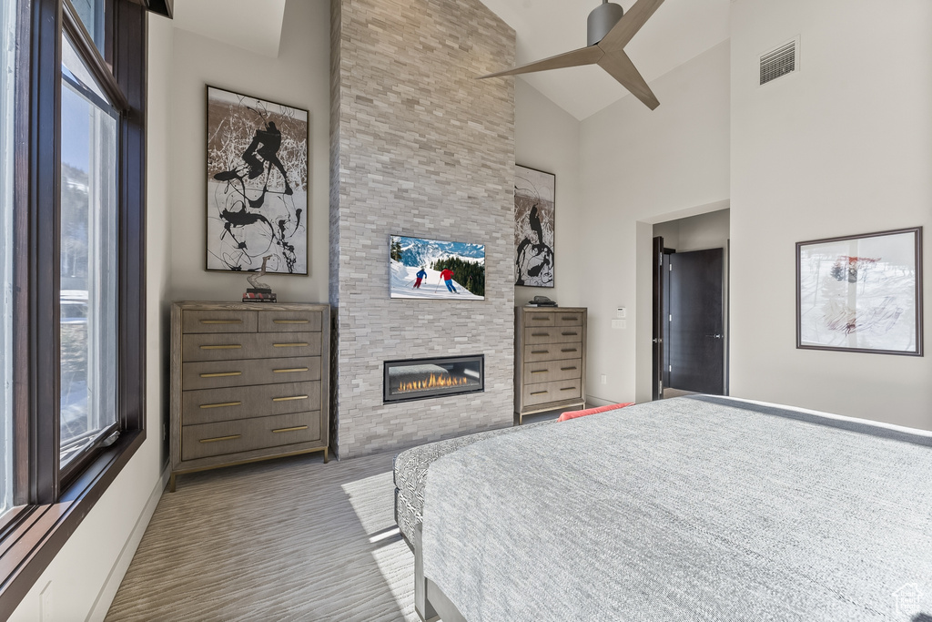 Bedroom featuring a fireplace, ceiling fan, and high vaulted ceiling