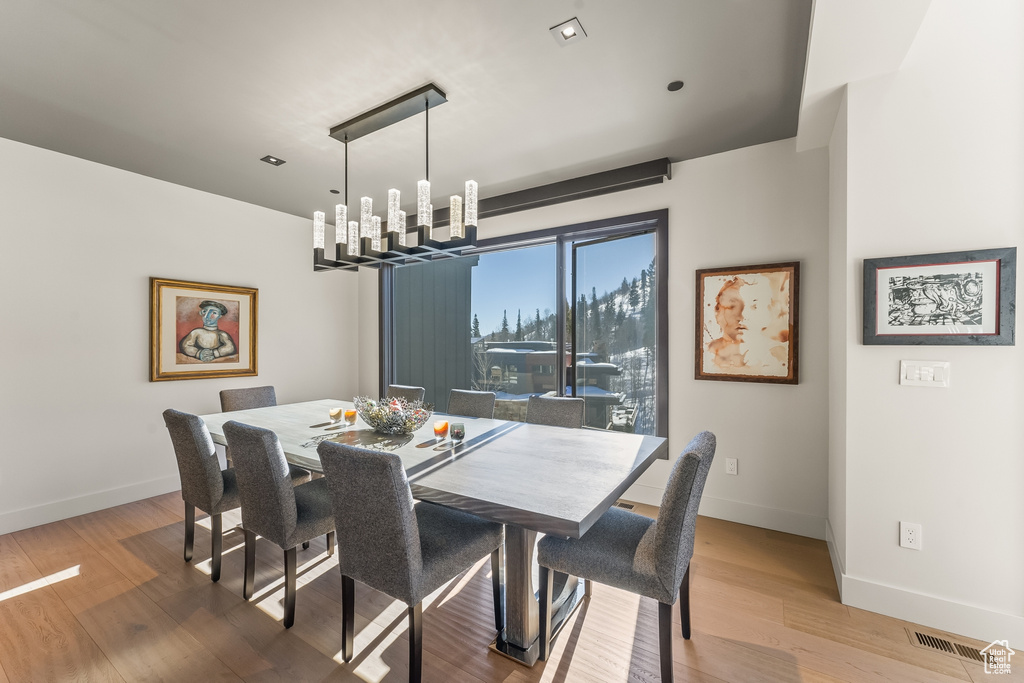 Dining space featuring light hardwood / wood-style flooring and a notable chandelier