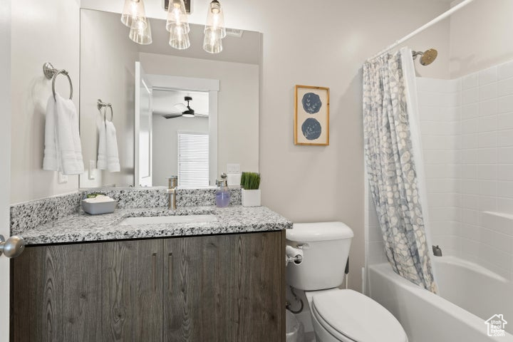 Full bathroom featuring vanity, toilet, shower / bath combination with curtain, and ceiling fan