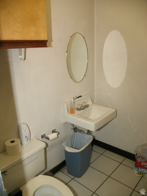 Bathroom with toilet, sink, and tile flooring