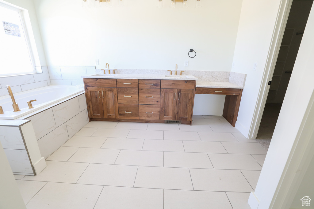 Bathroom with vanity, tiled bath, and tile floors