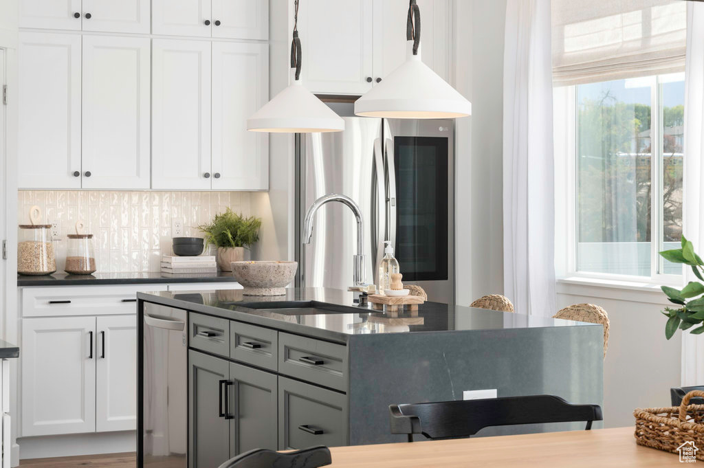 Kitchen featuring white cabinets, gray cabinets, sink, and backsplash