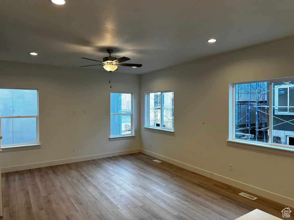 Unfurnished room with light hardwood / wood-style floors and ceiling fan