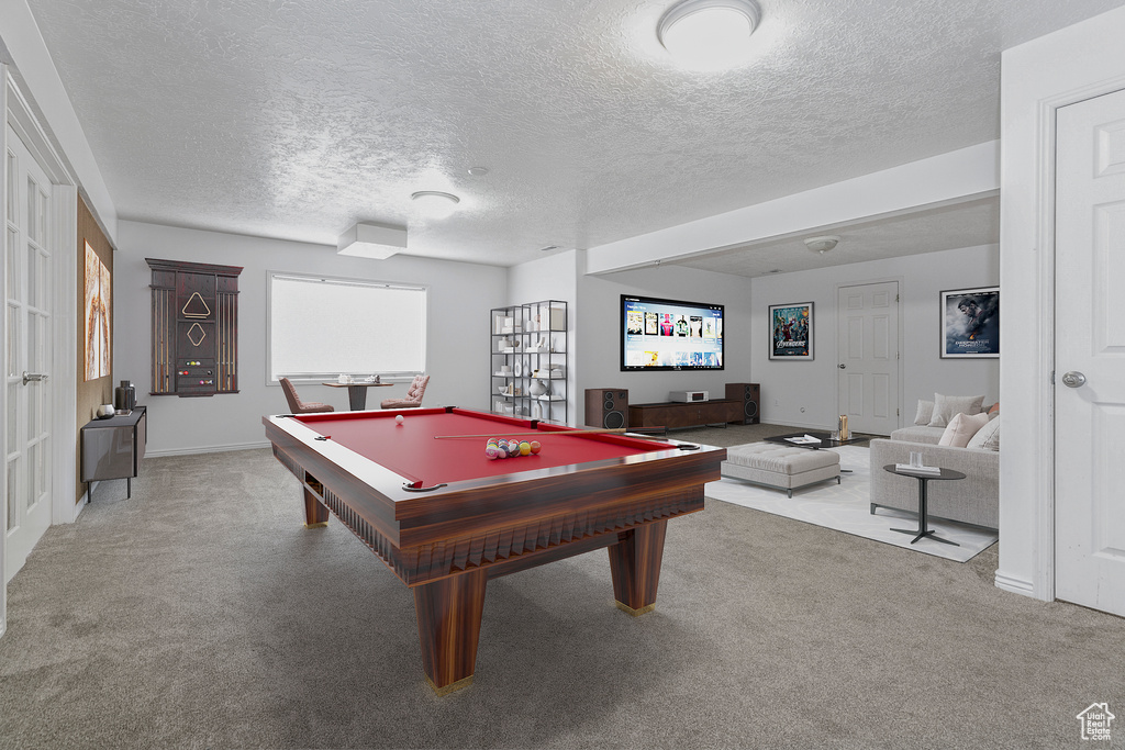 Game room with billiards, light colored carpet, and a textured ceiling