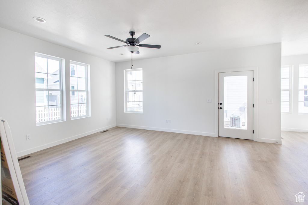 Empty room with light hardwood / wood-style flooring and ceiling fan