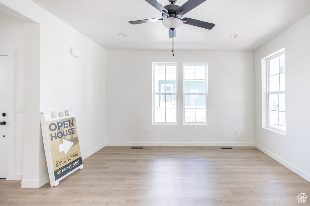 Unfurnished room with a healthy amount of sunlight, ceiling fan, and light wood-type flooring
