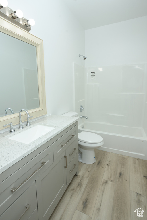 Full bathroom featuring vanity, toilet, hardwood / wood-style floors, and tub / shower combination