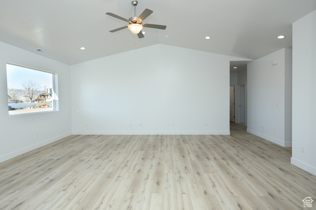 Unfurnished room featuring light hardwood / wood-style floors, ceiling fan, and vaulted ceiling