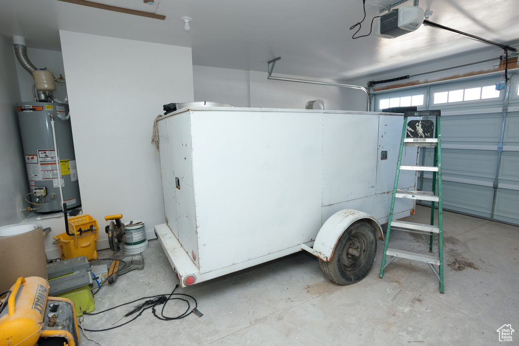 Garage with gas water heater and a garage door opener