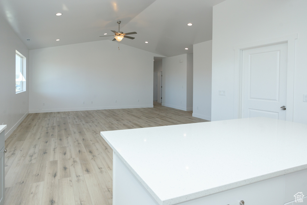 Spare room featuring light hardwood / wood-style flooring, ceiling fan, and vaulted ceiling