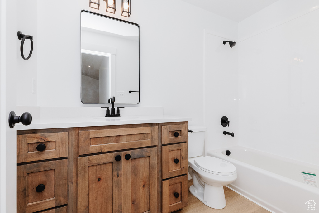 Full bathroom featuring vanity, toilet, hardwood / wood-style flooring, and bathing tub / shower combination
