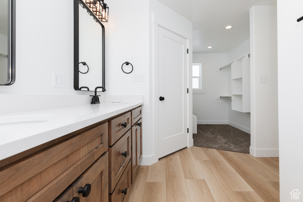 Bathroom featuring double vanity and wood-type flooring