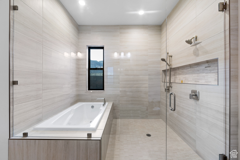Bathroom with tile walls and separate shower and tub