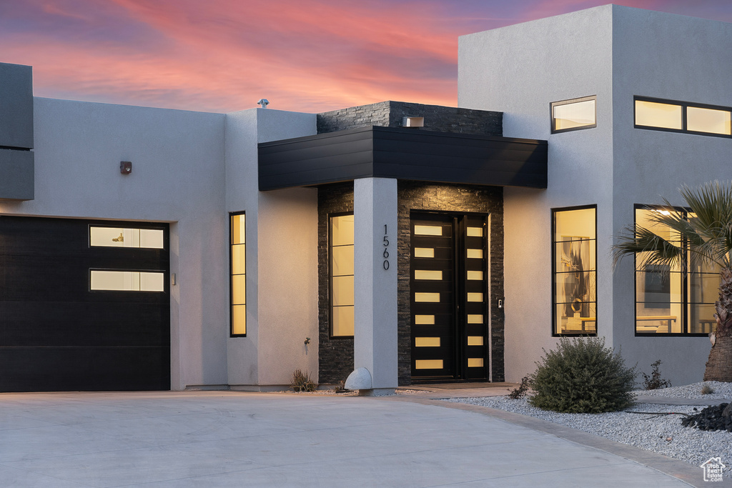 Exterior entry at dusk featuring a garage