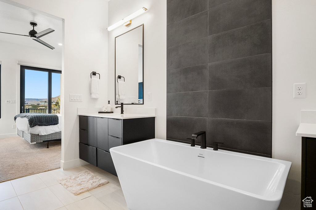 Bathroom featuring tile flooring, oversized vanity, ceiling fan, and a bathtub
