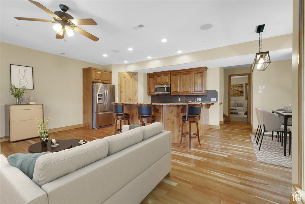 Living room featuring light hardwood / wood-style flooring and ceiling fan