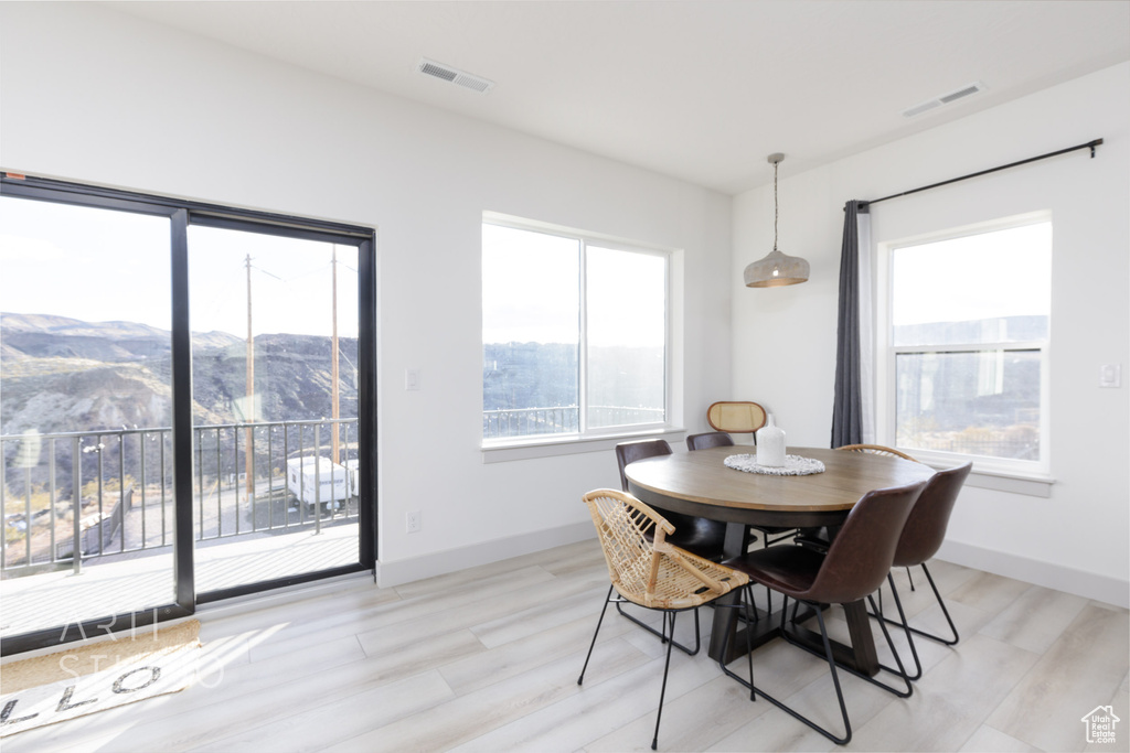 Dining area featuring a mountain view, plenty of natural light, and light hardwood / wood-style flooring