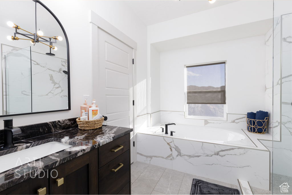 Bathroom featuring vanity, a chandelier, independent shower and bath, and tile flooring
