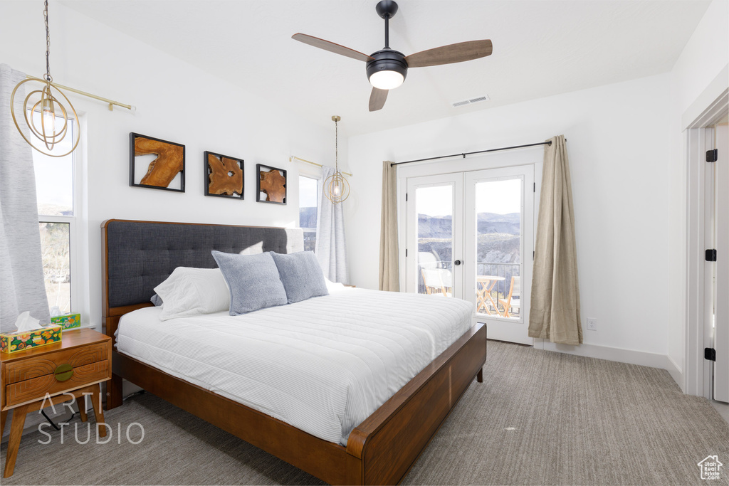 Carpeted bedroom featuring french doors, ceiling fan, a mountain view, and access to exterior