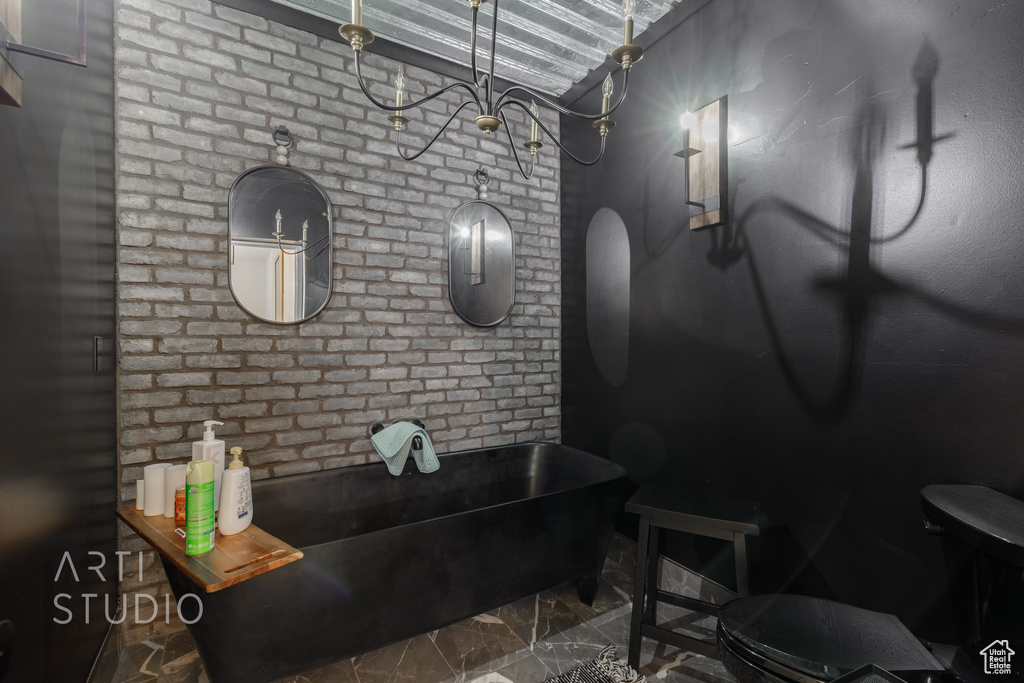 Bathroom featuring brick wall, a bathtub, tile floors, and toilet