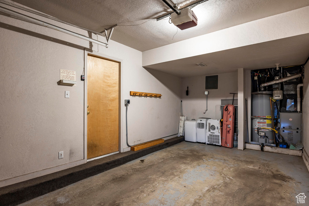 Garage featuring gas water heater, a garage door opener, and washer and dryer