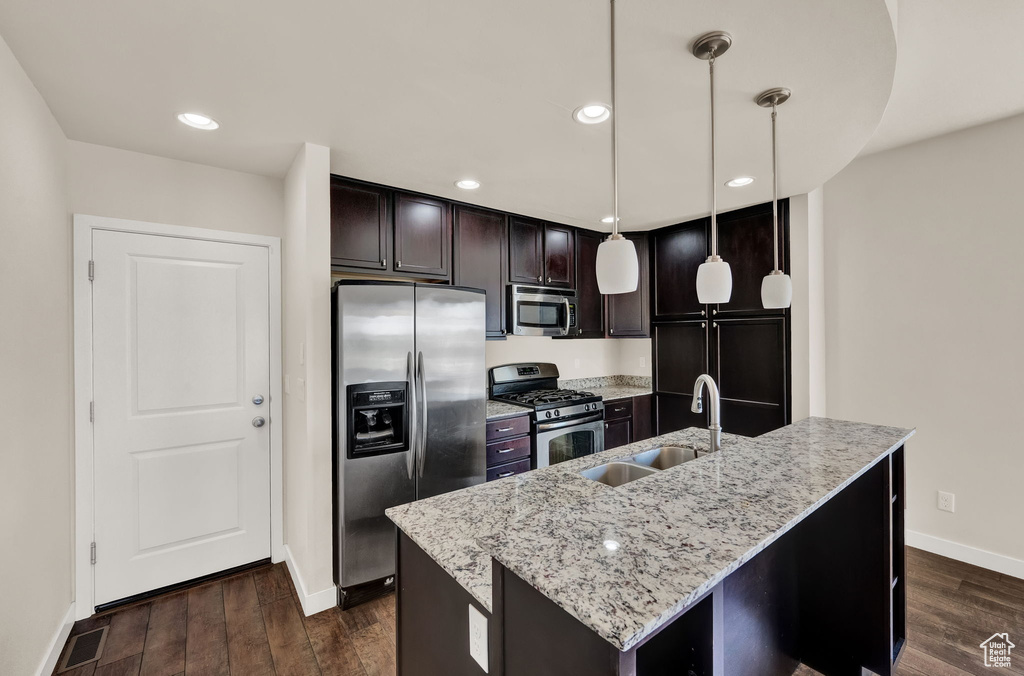 Kitchen featuring pendant lighting, sink, dark wood-type flooring, and stainless steel appliances