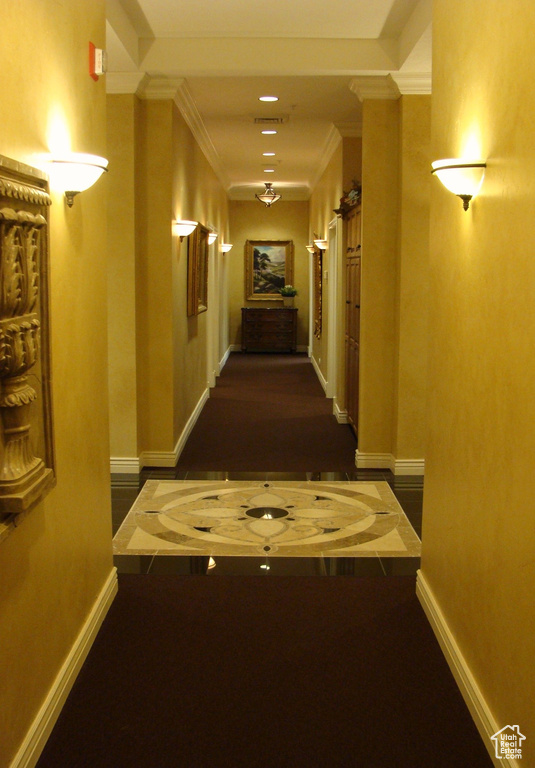Corridor featuring dark wood-type flooring and ornamental molding