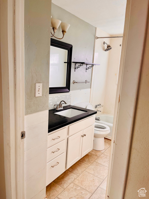Full bathroom with shower / washtub combination, toilet, tile flooring, backsplash, and oversized vanity