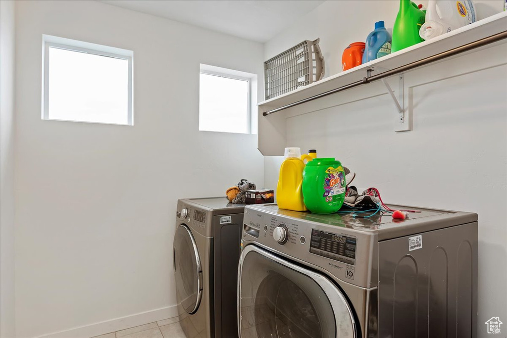 Clothes washing area with washing machine and clothes dryer and light tile flooring
