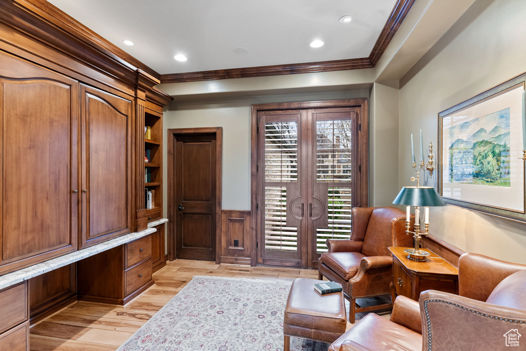 Sitting room with light hardwood / wood-style floors and crown molding