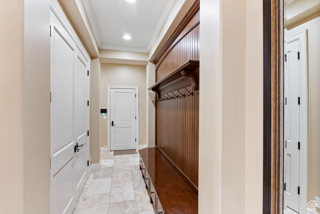 Mudroom with light tile floors and ornamental molding