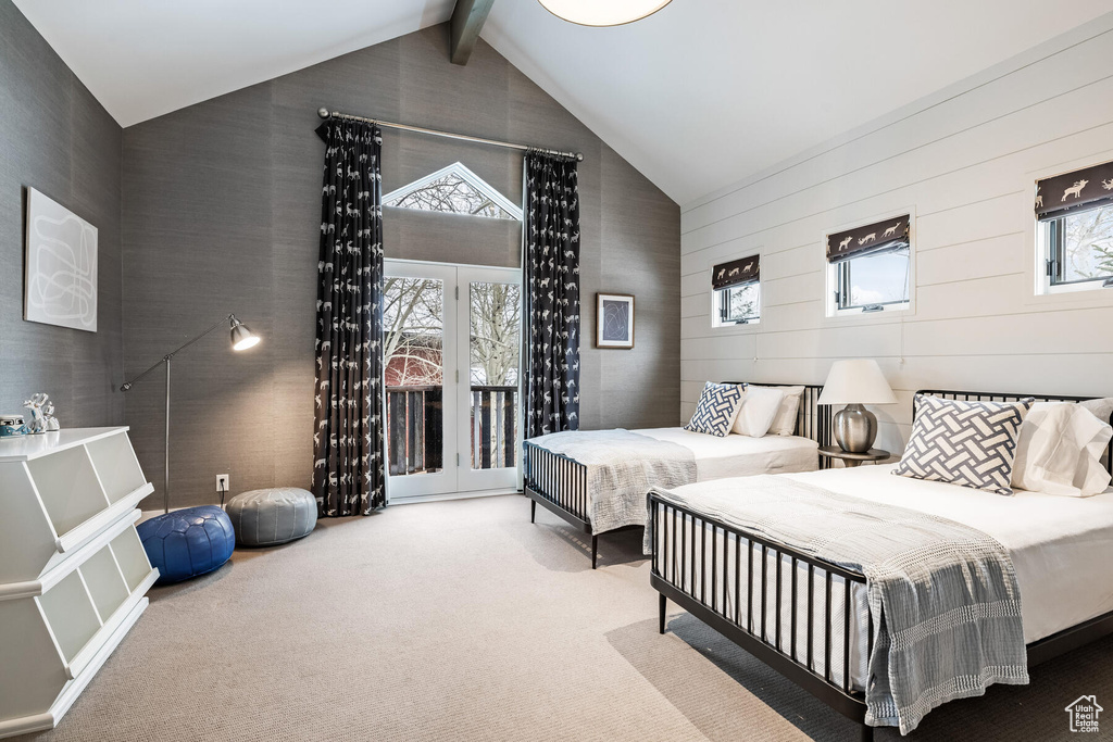 Carpeted bedroom featuring access to outside, beamed ceiling, multiple windows, and french doors