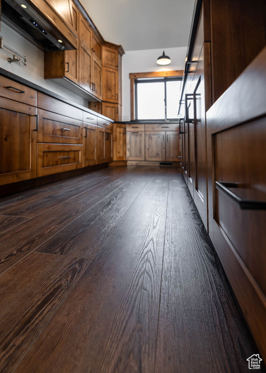 Interior space with custom exhaust hood and dark wood-type flooring