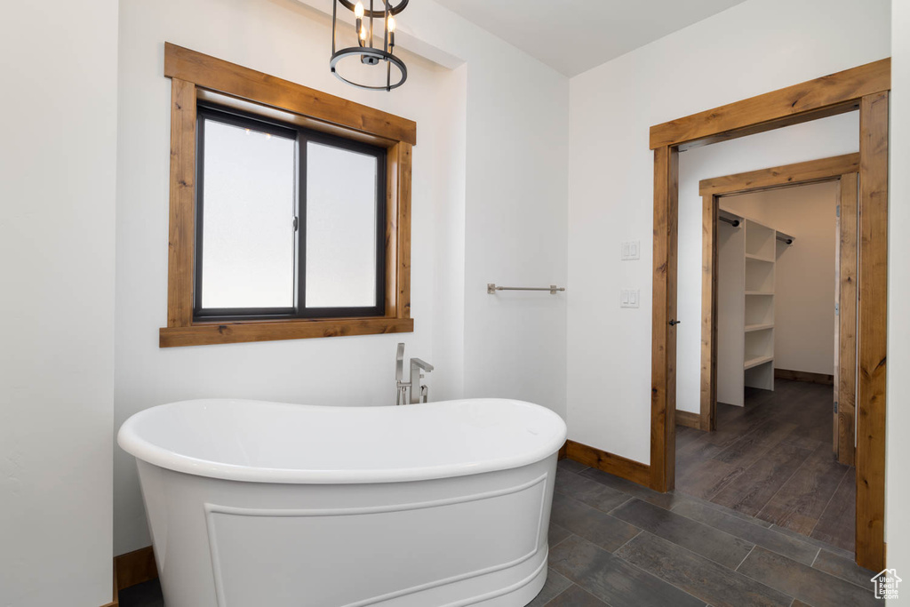 Bathroom with hardwood / wood-style flooring and a washtub