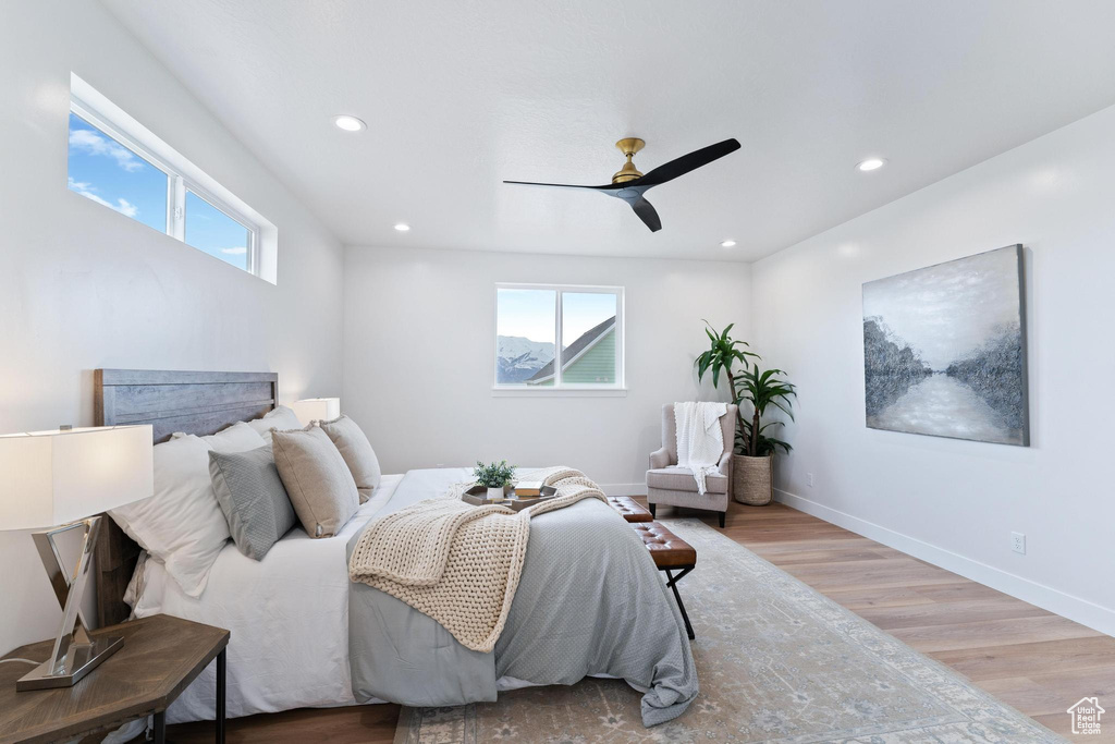 Bedroom featuring light wood-type flooring, multiple windows, and ceiling fan