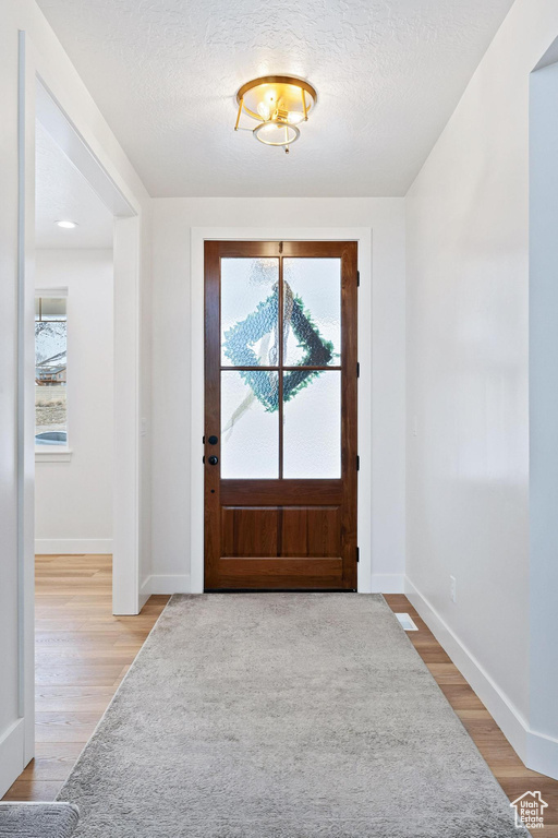 Entryway featuring light hardwood / wood-style flooring and a textured ceiling