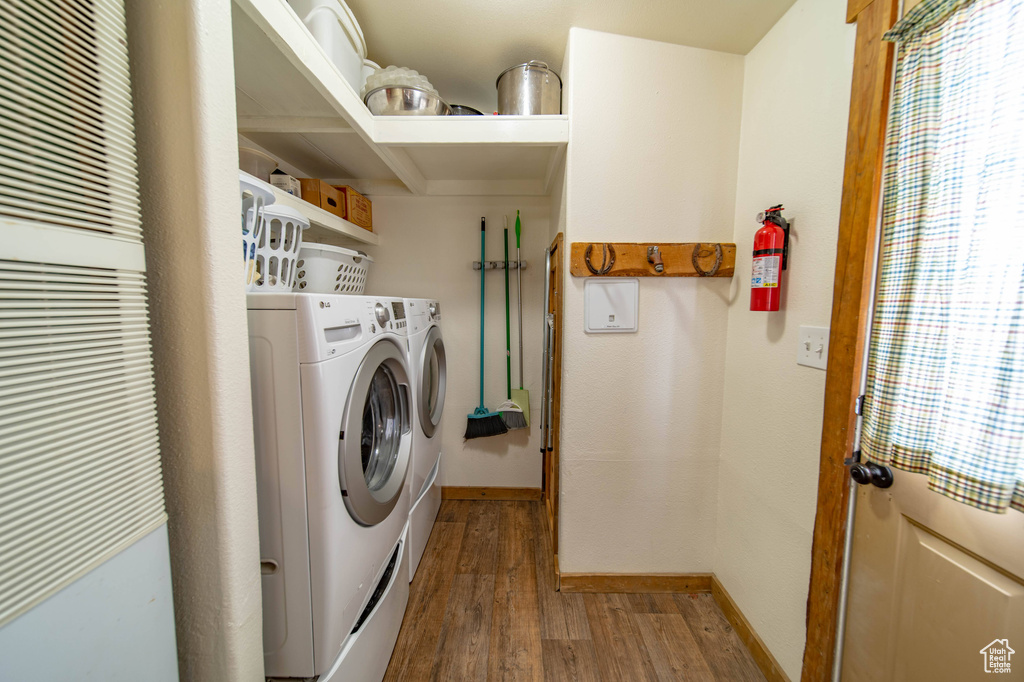 Laundry room with independent washer and dryer and wood-type flooring